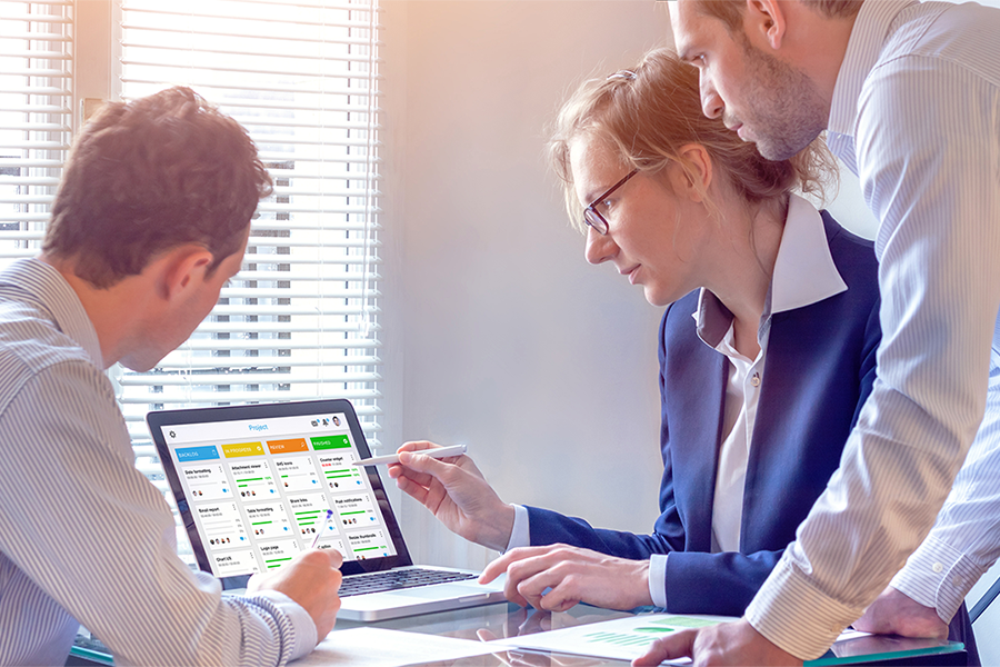 Image of people in a meeting looking at data on a laptop