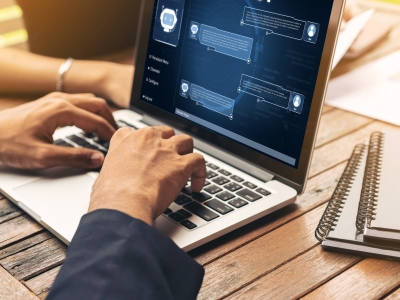 Image showing a person typing on a laptop and chatting with an AI assistant